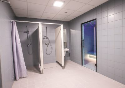 Zdjęcie przedstawiające prysznice w budynku basenu krytego